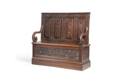 un vieux banc en bois dont le dossier est orné de sculptures