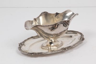 une assiette en argent posée sur une soucoupe, le tout sur une surface blanche