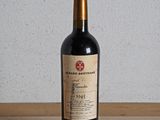 a bottle of red wine sitting on a wooden table
