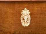 an old picture of a brown velvet case with a picture of a man in a crown on it