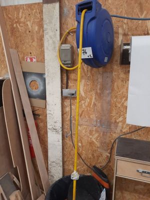 a picture of a room with a bucket and a hose attached to the wall