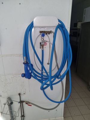 un tuyau bleu fixé au mur d'une salle de bains