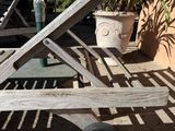 a wooden chair that is sitting on the sidewalk