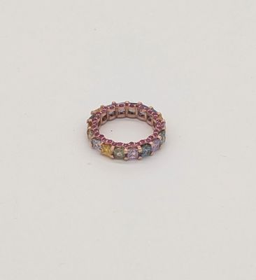 La bague est composée de pierres multicolores et repose sur un fond blanc.