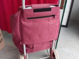 a pink shopping cart with a pink bag on top of it