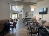des tables et des chaises dans un restaurant, avec une télévision à écran plat accrochée au mur