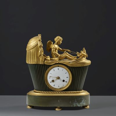 a gold clock with a statue on top of it