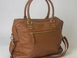 a brown leather handbag sitting on top of a white table