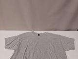 a grey t shirt sitting on top of a white table