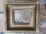 a picture of a gold picture frame on a brick floor