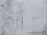 une image représentant une plaque en pierre sur laquelle figure un bateau