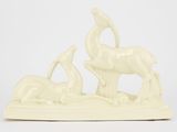 figurine en céramique blanche représentant deux cerfs et un oiseau posés sur un rocher