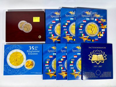 several books with gold and silver coins on them on a white surface