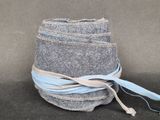 une pile de jeans enveloppée dans un ruban bleu
