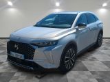 une voiture argentée garée dans une pièce au sol en damier
