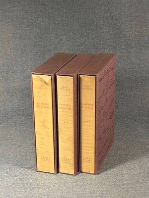 three books are stacked on top of each other on a gray surface