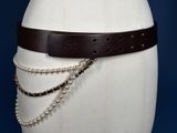 a white mannequin torso with a brown belt on it
