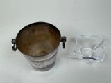 a silver bucket and a glass holder on a table