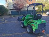 a small green tractor that is parked in a parking lot