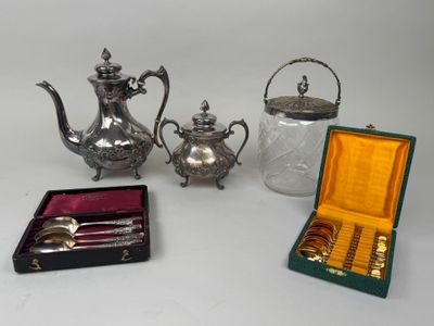 three pieces of silverware including a teapot, spoons, and a teapot
