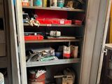 une armoire métallique sur laquelle sont posés de nombreux objets, dans un garage