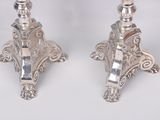 pair of silver candlesticks with ornate designs on each of them