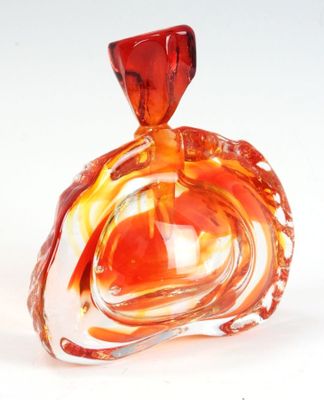 une bouteille en verre avec un bouchon rouge posée sur une table