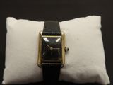 a close up of a wrist watch on a pillow on a table