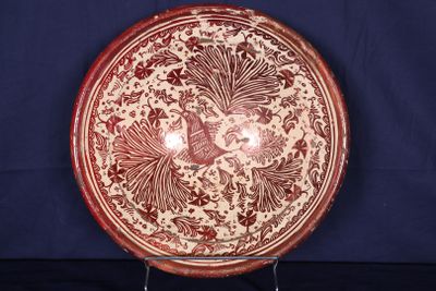 une assiette rouge et blanche ornée d'un motif représentant un oiseau