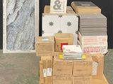 une pile de cartons posée sur une palette devant un mur noir