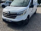 une camionnette blanche garée dans un parking à côté d'autres voitures