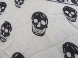 a black and white picture of skulls on a bed