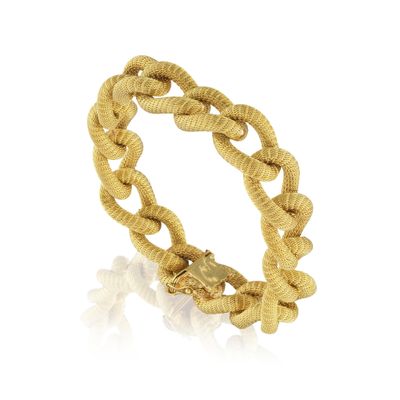 gros plan d'un bracelet en or sur fond blanc
