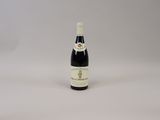 une bouteille de vin posée sur une table blanche