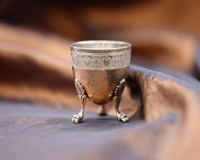 a silver cup sitting on top of a cloth