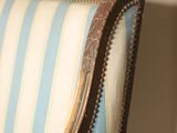 a blue and white striped chair with a gold trim