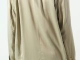 the back view of a woman wearing a khaki jacket and white pants