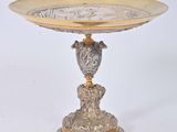 a silver and gold plate with a bird on it
