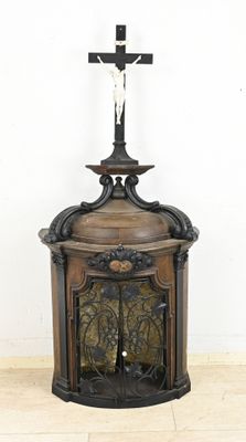 a cross on top of a wooden cabinet with a cross on top of it