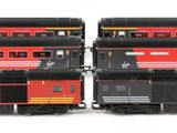 three red and yellow trains sitting side by side on a white surface