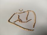 une photo d'un collier en or posé sur une surface blanche