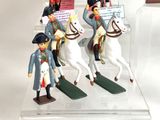 three figurines of men riding horses in a display case