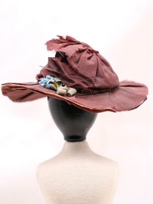 chapeau violet orné de fleurs, posé sur la tête d'un mannequin