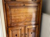 a wooden cabinet with two blue and white vases on top of it