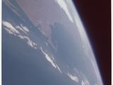 une image représentant une vue de la Terre depuis l'espace, avec une navette spatiale au premier plan