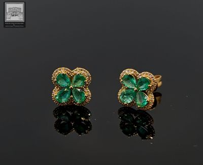 a pair of emerald and diamond earrings
