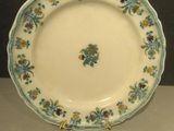 une assiette blanche décorée de fleurs bleues et jaunes