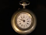 a silver pocket watch with roman numerals on it