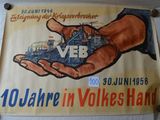 a poster on the wall of a building with a hand holding a model of a building