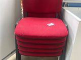 une chaise rouge qui se trouve à côté d'un réfrigérateur